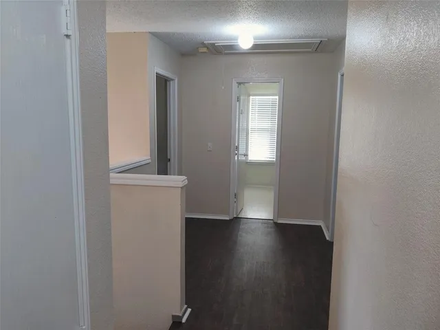 a view of a room with wooden floor and a window