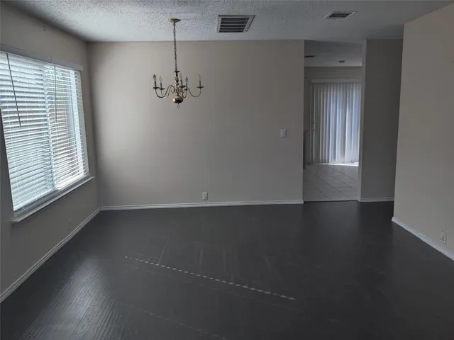 an empty room with windows and cabinet