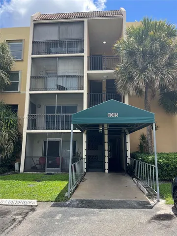 a front view of a house with a garden and trees