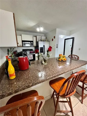 a kitchen with stainless steel appliances granite countertop sink stove and cabinets