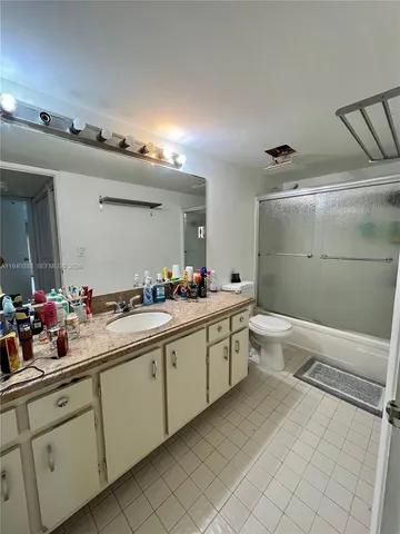 a large white bathroom with a sink mirror and a bathtub