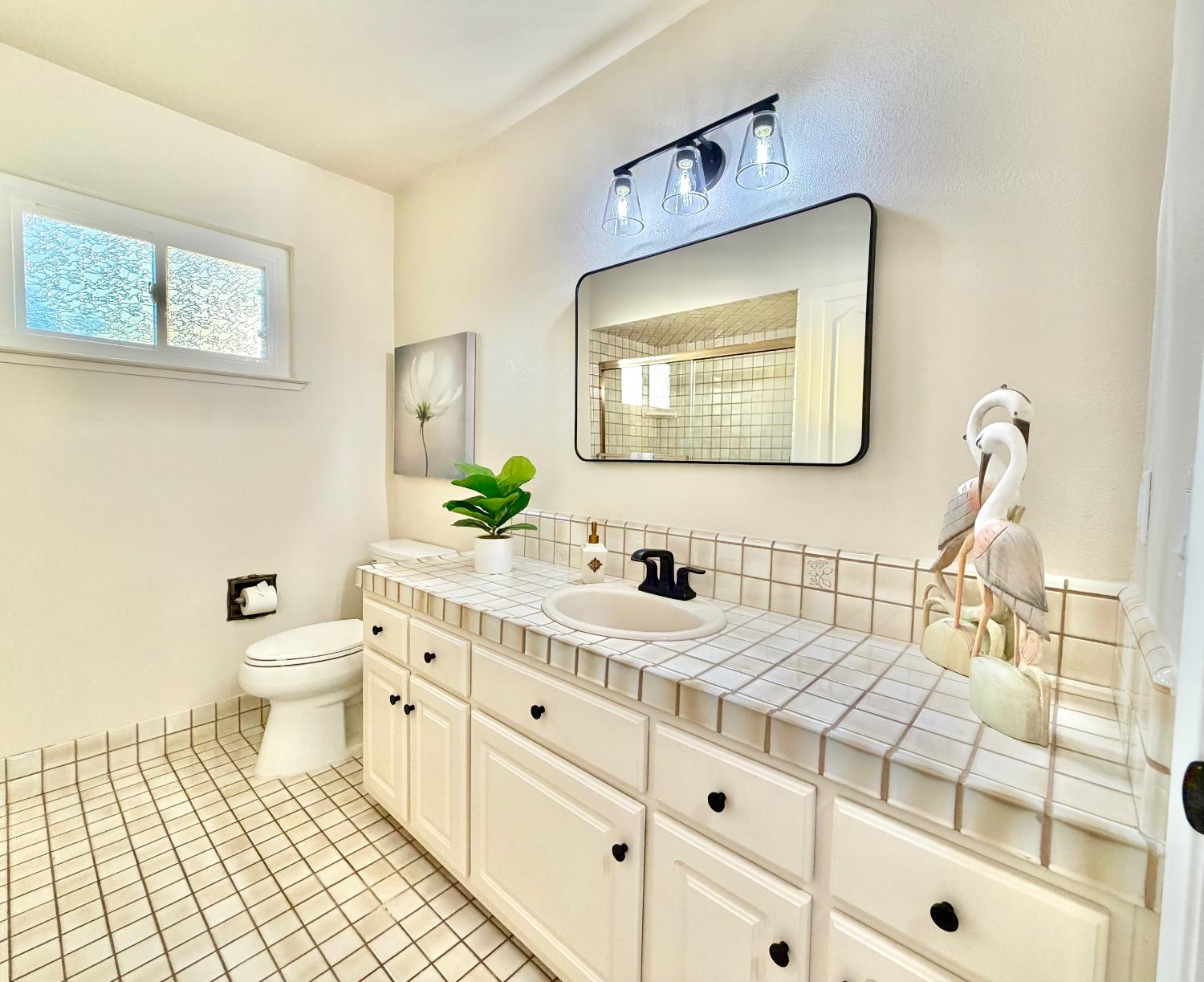 5706 Jeff Way Carmichael, CA 95608 - Photo 12 of 48 Fresh updates on classic designed hall bath with tub shower and glass enclosed doors. New toilet, mirror, lights, paint, hardware and faucet.