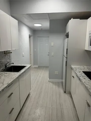 a kitchen with a sink and refrigerator