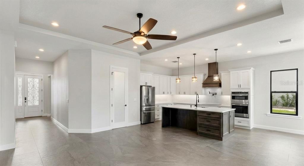 224 Valencia Ridge Drive Auburndale, FL 33823 - Photo 9 of 39 a large kitchen with stainless steel appliances kitchen island granite countertop a refrigerator and a sink