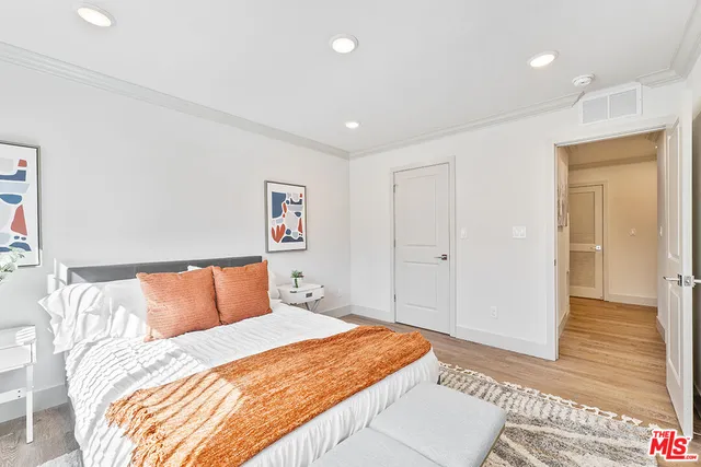 a bedroom with bed and wooden floor