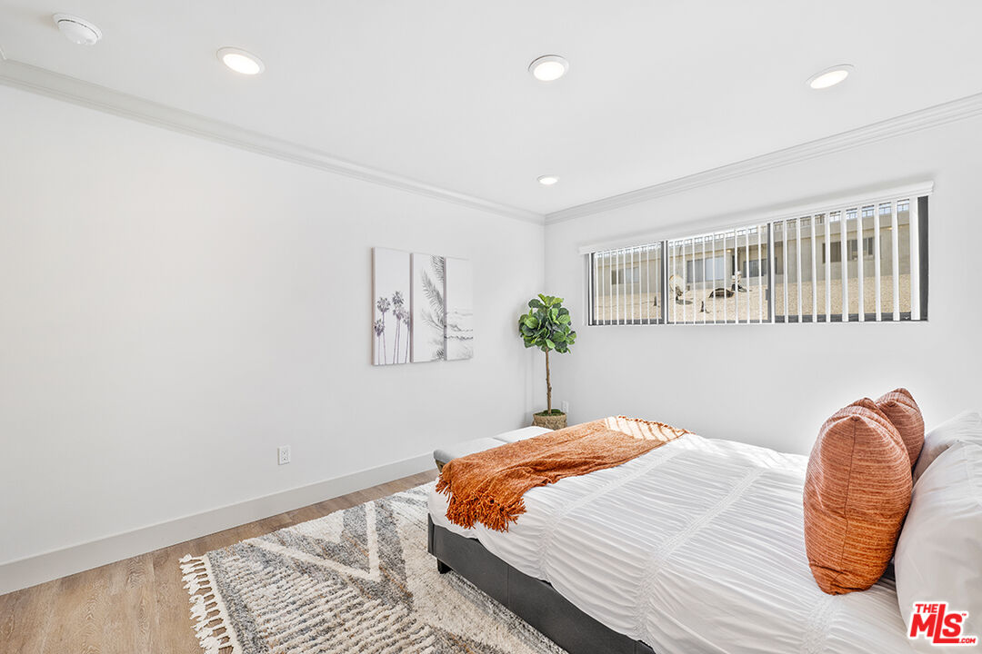 821 3rd Street, Unit 209 Santa Monica, CA 90403 - Photo 12 of 25 a bedroom with a bed and a chair