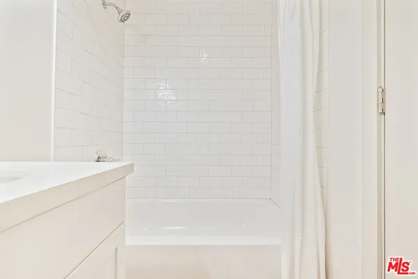 a bathroom with a shower and a sink