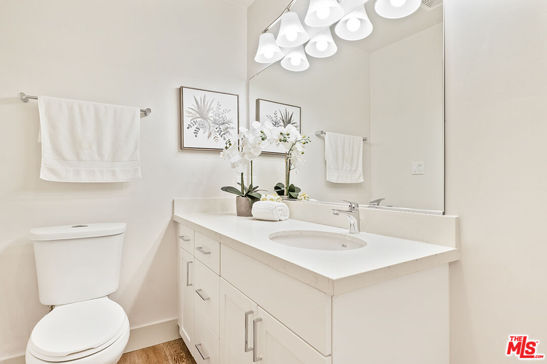 821 3rd Street, Unit 209 Santa Monica, CA 90403 - Photo 15 of 25 a bathroom with a toilet sink and mirror