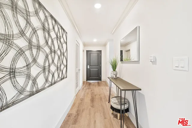 a view of a hallway with wooden floor and staircase