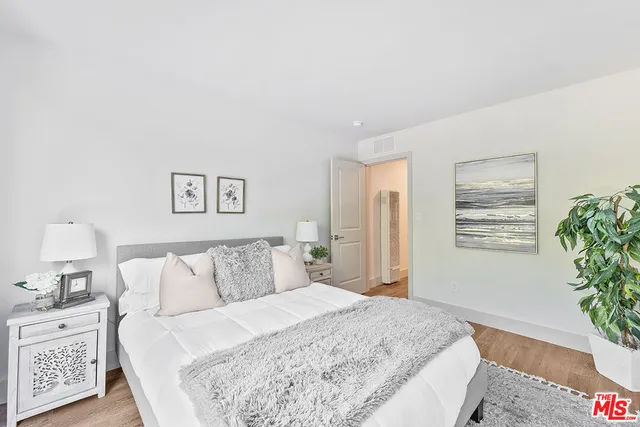 a bedroom with a bed and a potted plant