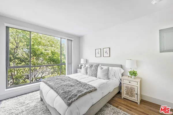 a bedroom with a bed and a large window