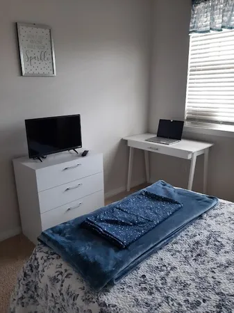 a living room with a rug and a flat screen tv