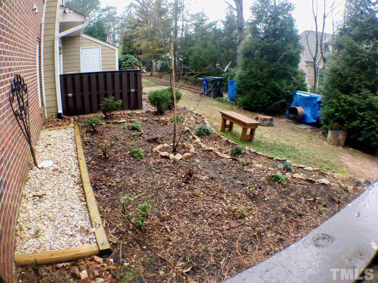 3533 Mill Run, Unit N/A Raleigh, NC 27612 - Photo 11 of 19 a view of a backyard with potted plants and large tree