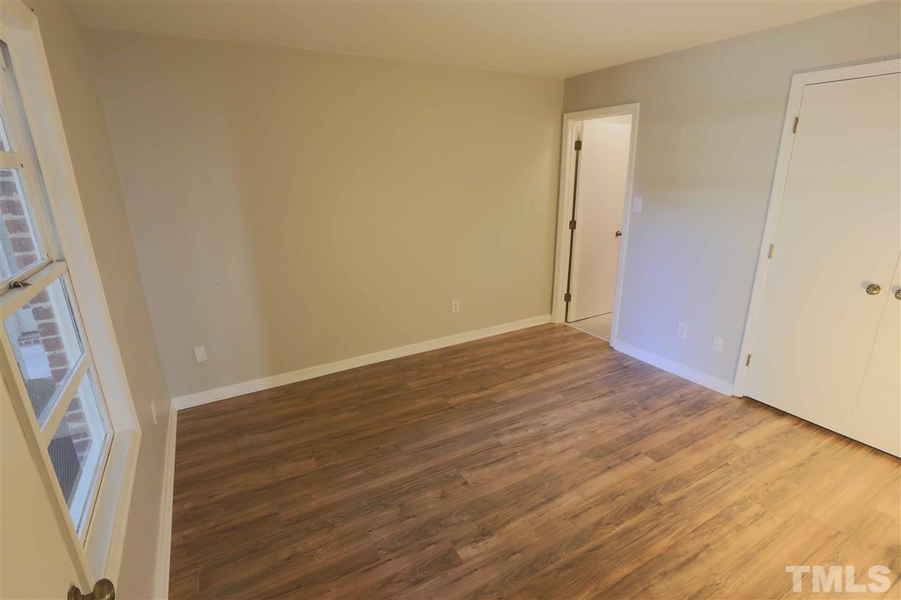 3533 Mill Run, Unit N/A Raleigh, NC 27612 - Photo 12 of 19 an empty room with wooden floor and entrance