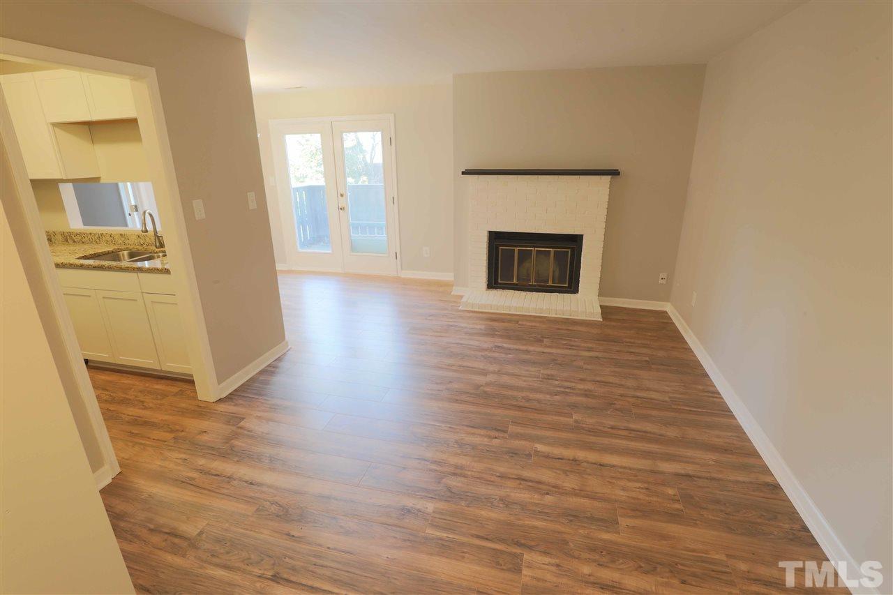 3533 Mill Run, Unit N/A Raleigh, NC 27612 - Photo 3 of 19 a view of an empty room with a fireplace and a window