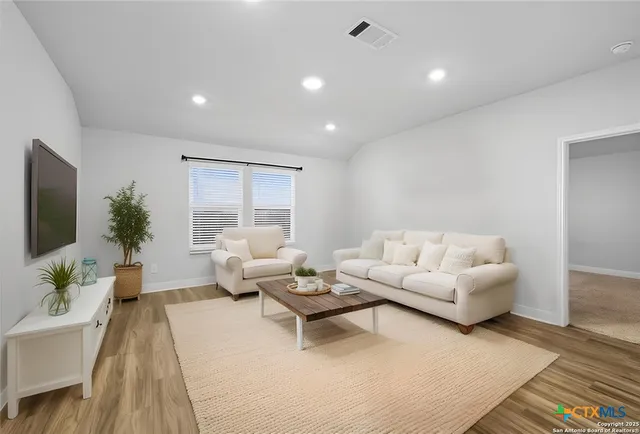 a spacious bedroom with a bed and a flat screen tv