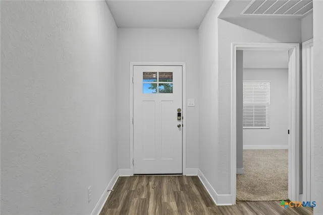 a view of a hallway with wooden floor and staircase