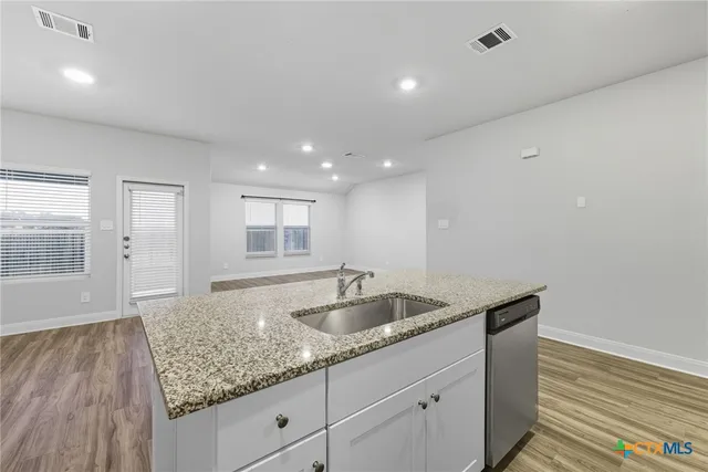 a large kitchen with stainless steel appliances granite countertop a stove a sink and a refrigerator