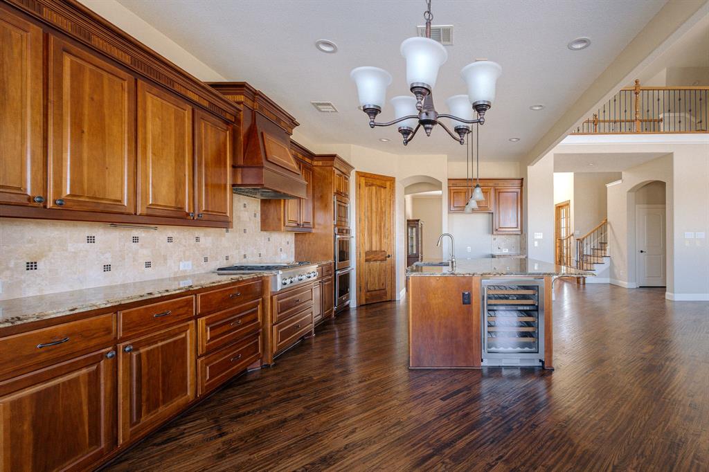 2207 Galloway Boulevard Trophy Club, TX 76262 - Photo 11 of 36 a kitchen with stainless steel appliances granite countertop a refrigerator a sink dishwasher a stove and white cabinets with wooden floor