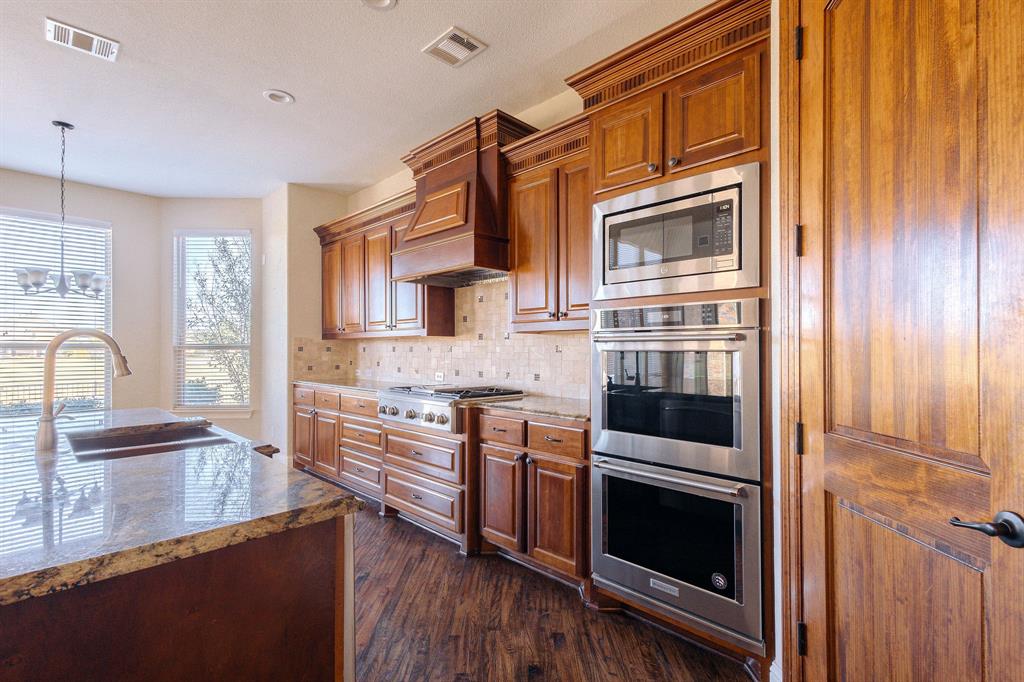 2207 Galloway Boulevard Trophy Club, TX 76262 - Photo 10 of 36 a kitchen with stainless steel appliances granite countertop a stove and a sink