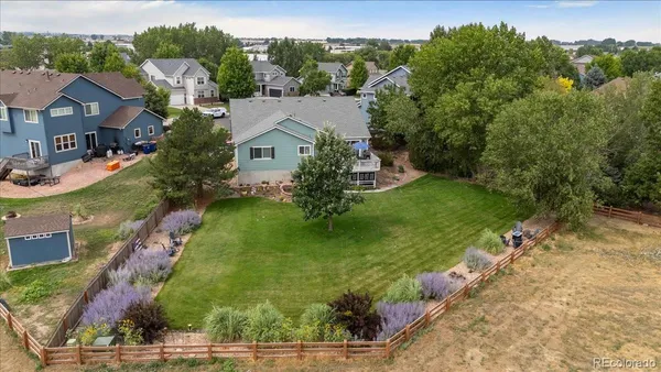 an aerial view of residential houses with outdoor space and trees