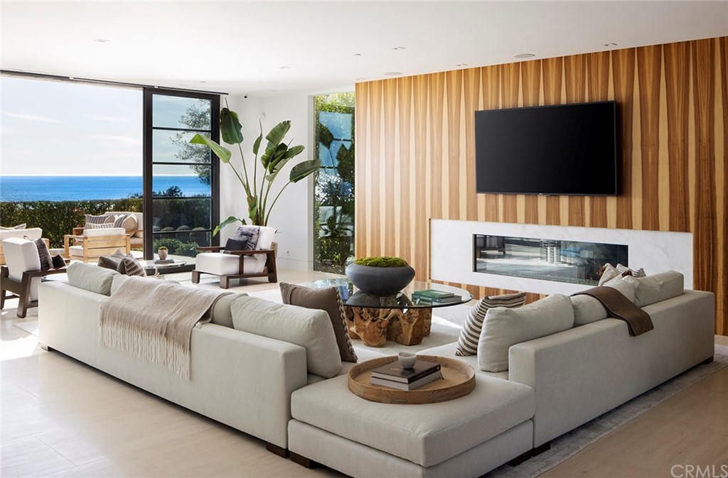 2914 Ocean Boulevard Corona del Mar, CA 92625 - Photo 9 of 60 a living room with furniture a flat screen tv and a fireplace