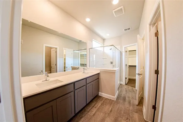 a bathroom with a double vanity sink a mirror and a shower
