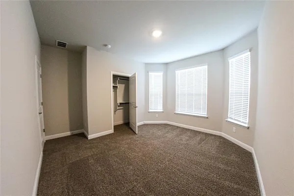 an empty room with windows and closet