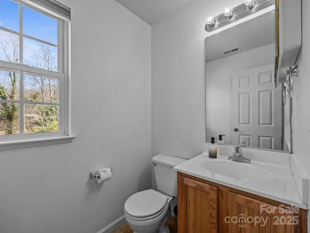 a bathroom with a granite countertop sink mirror vanity and toilet