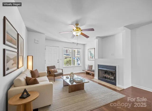 a living room with furniture fireplace and a large window