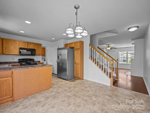 a open kitchen with stainless steel appliances granite countertop a refrigerator a stove top oven a sink and dishwasher