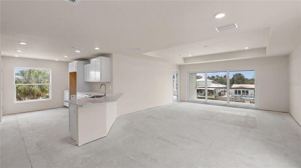3498 Centavo Court Hernando Beach, FL 34607 - Photo 14 of 44 a view of an empty room with a window and a kitchen area