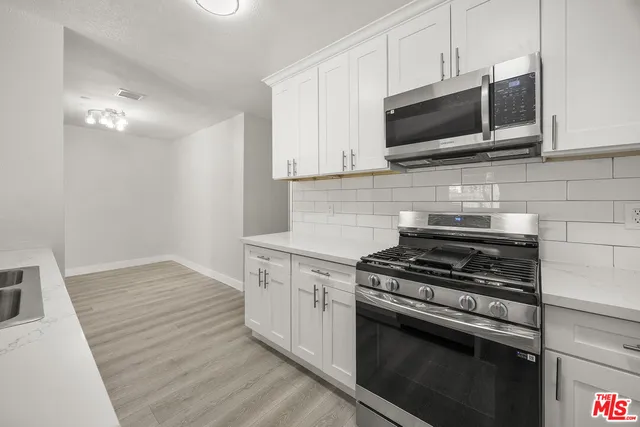 a kitchen with cabinets and steel appliances
