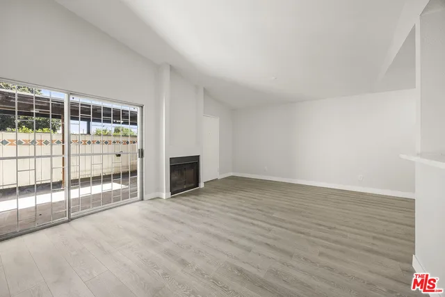 a view of an empty room with a fireplace and a window