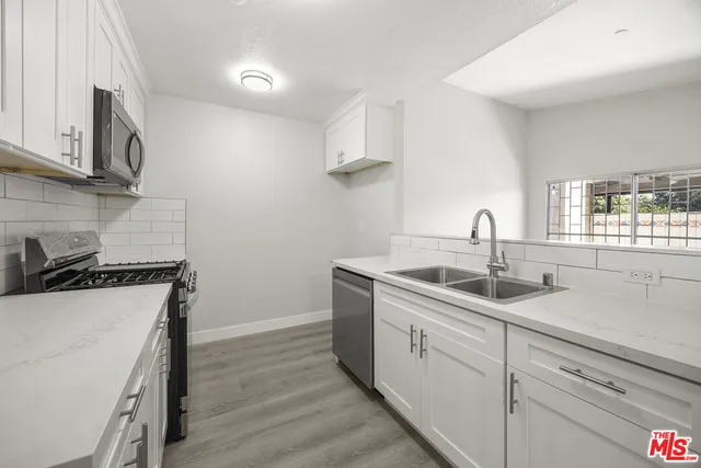 a kitchen with a sink stove and cabinets