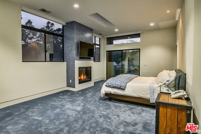 a spacious bedroom with a bed and a flat screen tv