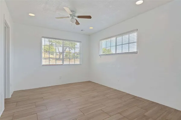wooden floor in an empty room with a kitchen