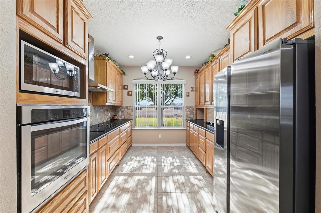 517 Hiwasee Road Waxahachie, TX 75165 - Photo 11 of 38 a kitchen with stainless steel appliances granite countertop a refrigerator and a stove