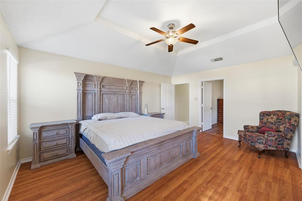 517 Hiwasee Road Waxahachie, TX 75165 - Photo 14 of 38 a spacious bedroom with a bed and a chandelier