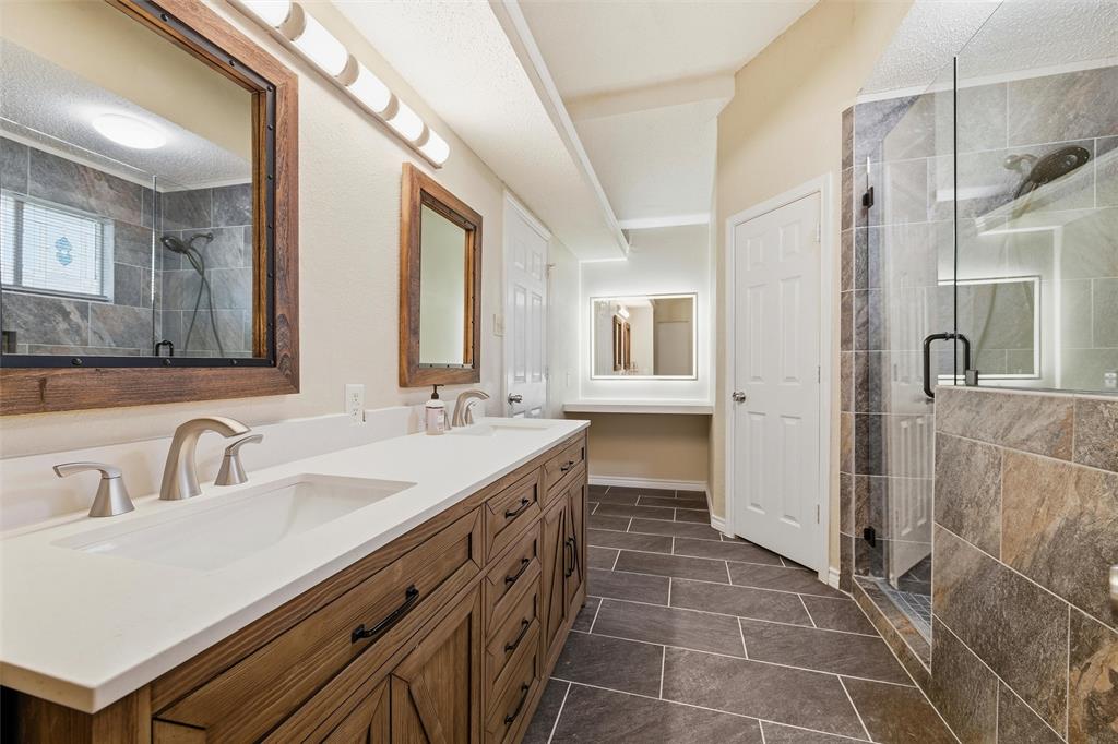 517 Hiwasee Road Waxahachie, TX 75165 - Photo 16 of 38 a spacious bathroom with a double vanity sink a mirror and a shower