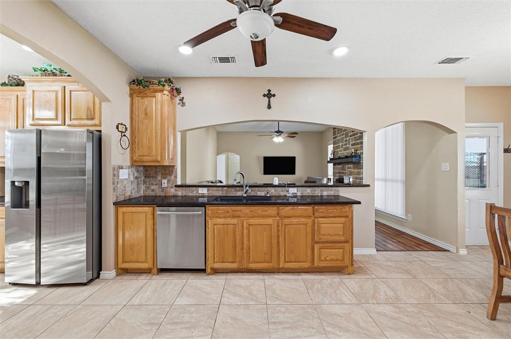 517 Hiwasee Road Waxahachie, TX 75165 - Photo 7 of 38 a kitchen with stainless steel appliances granite countertop a refrigerator and a sink