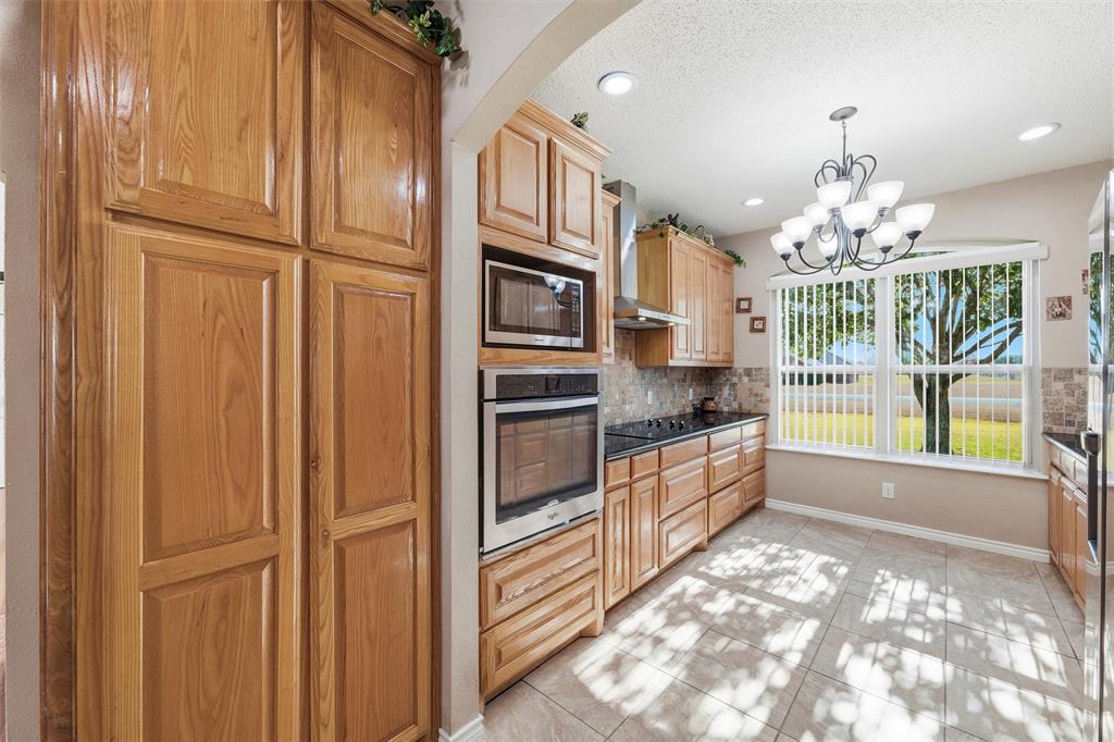 517 Hiwasee Road Waxahachie, TX 75165 - Photo 9 of 38 a kitchen with stainless steel appliances granite countertop a refrigerator and a stove top oven