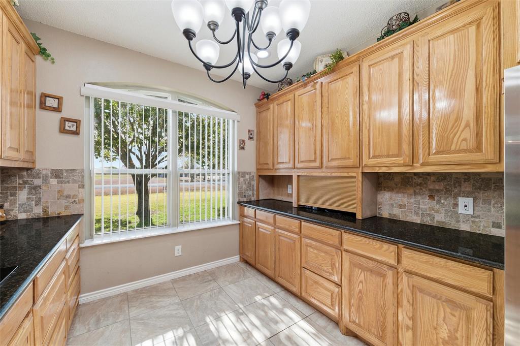 517 Hiwasee Road Waxahachie, TX 75165 - Photo 10 of 38 a kitchen with stainless steel appliances granite countertop a stove a sink and dishwasher cabinets with wooden floor