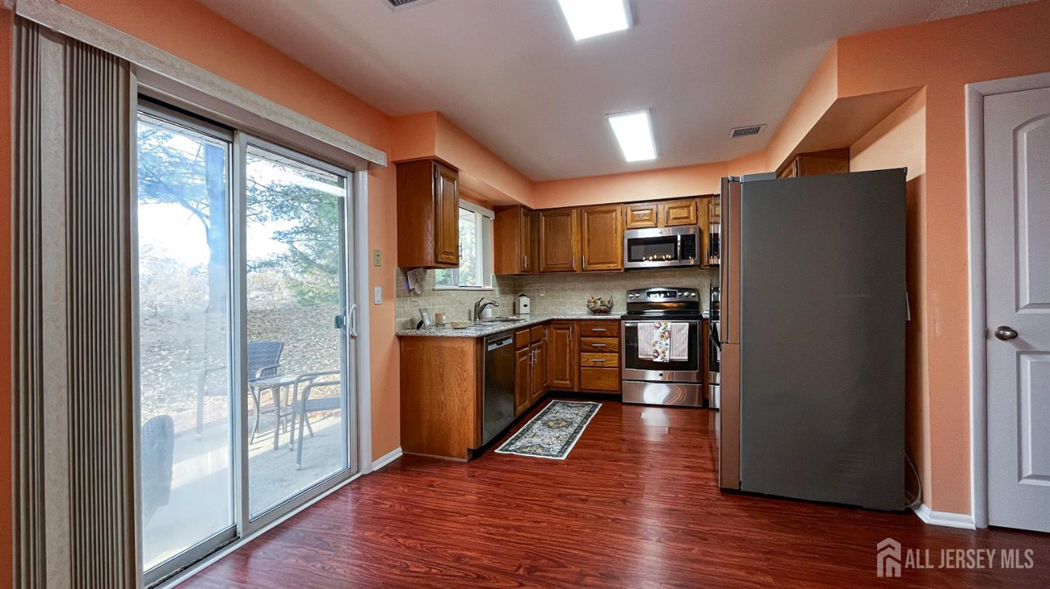 719 Delair Road, Unit B Monroe Township, NJ 08831 - Photo 9 of 21 a kitchen with stainless steel appliances granite countertop a refrigerator a sink dishwasher a stove and a dining table with wooden floor