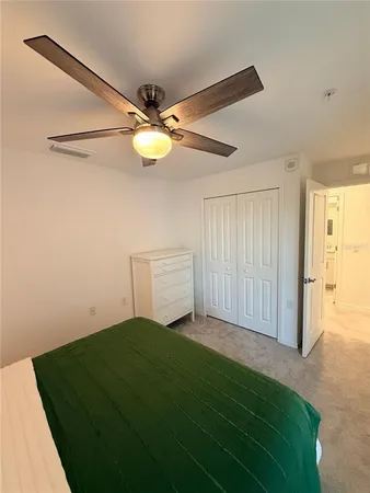 a view of a big room with closet and a ceiling fan