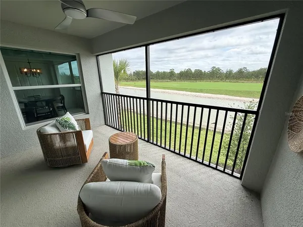 a living room with furniture and a floor to ceiling window