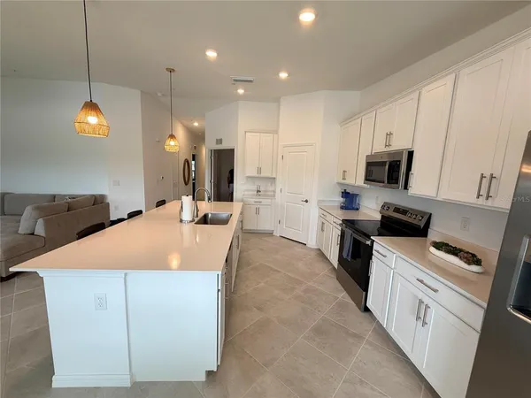 a large kitchen with kitchen island a sink stainless steel appliances and cabinets