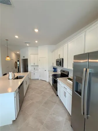 a large kitchen with a refrigerator a sink a stove top oven and a center island