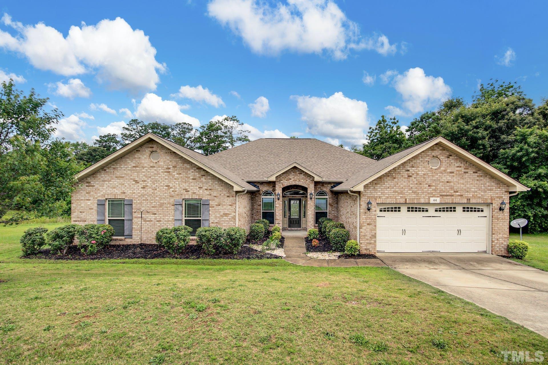 a view of a house with garden and a yard