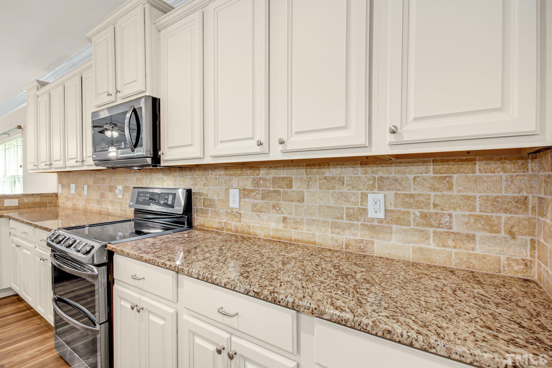 44 Destiny Circle Angier, NC 27501 - Photo 17 of 35 a kitchen with granite countertop white cabinets and stainless steel appliances